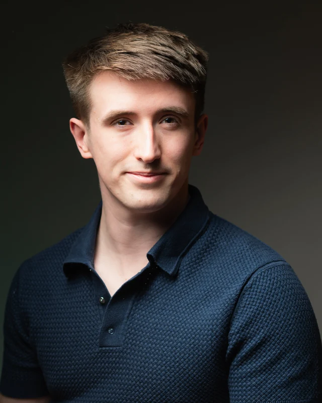 Michael Seeds, photographer, in a navy polo shirt against a dark backdrop